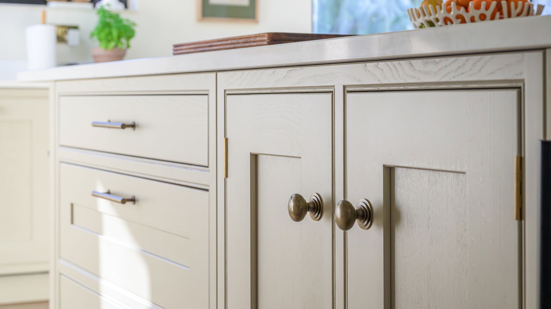 An image showing a close up of an in-frame kitchens UK cabinet with beautiful handles.